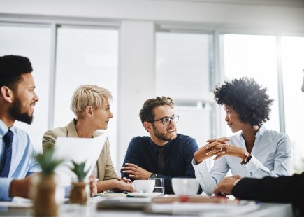 group of young professionals gather around boardroom table