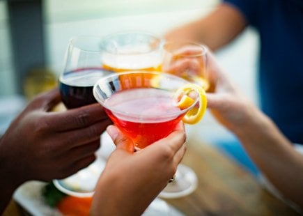 close up shot of wine and cocktails being cheersed 