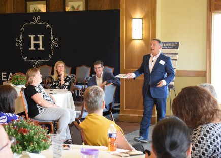 A man giving a speech to a room full of people.