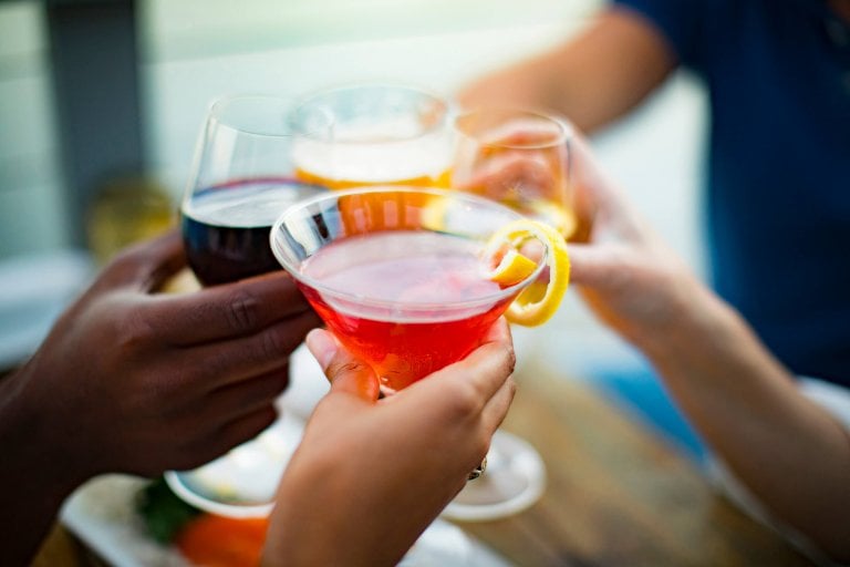 close up shot of wine and cocktails being cheersed 