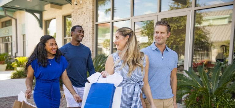 A group of adult shoppers in front of a store