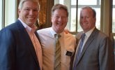 Three well dressed men posing for a picture